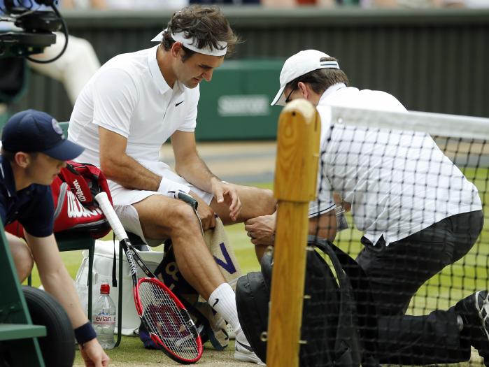 Roger Federer of Switzerland receives medical attention during his men's semi-final singles match against Milos Raonic of Canada this year