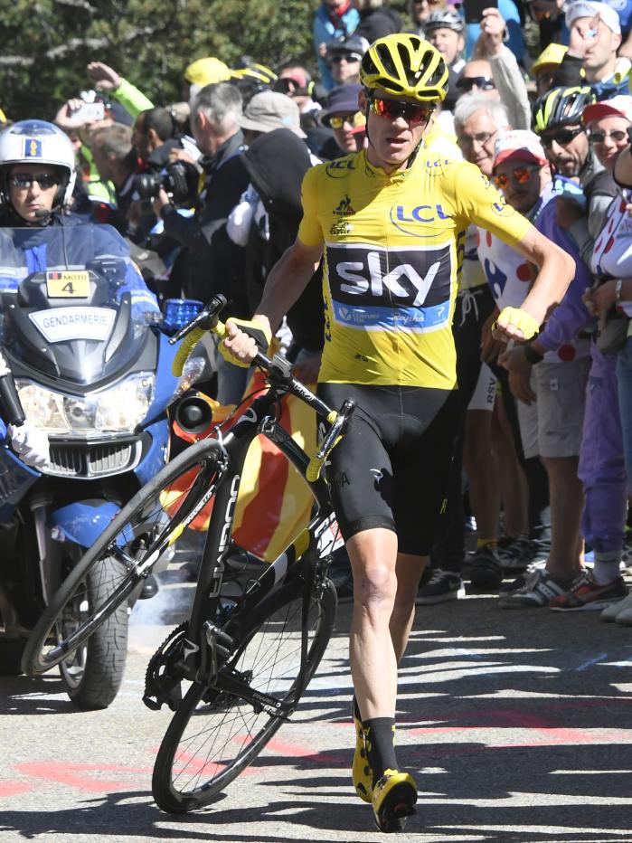Froome carrying his broken bike after a collision with moto media
