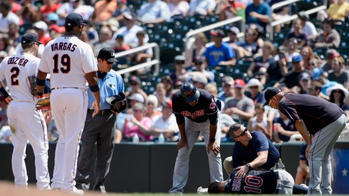 Dozier and Vargas look on as the Cleveland Indians trainer checks on Gomes following his injury