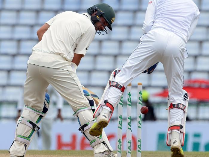 Australia's Joe Burns looks back at his stumps after being bowled by Lakshan Sandakan.